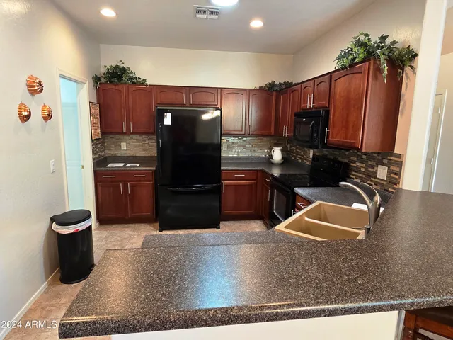a kitchen with stainless steel appliances granite countertop a refrigerator and a sink