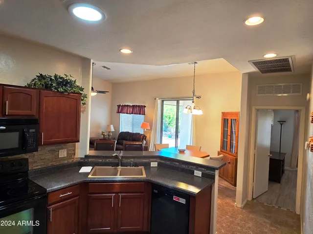 a kitchen with stainless steel appliances granite countertop a sink a stove and a refrigerator