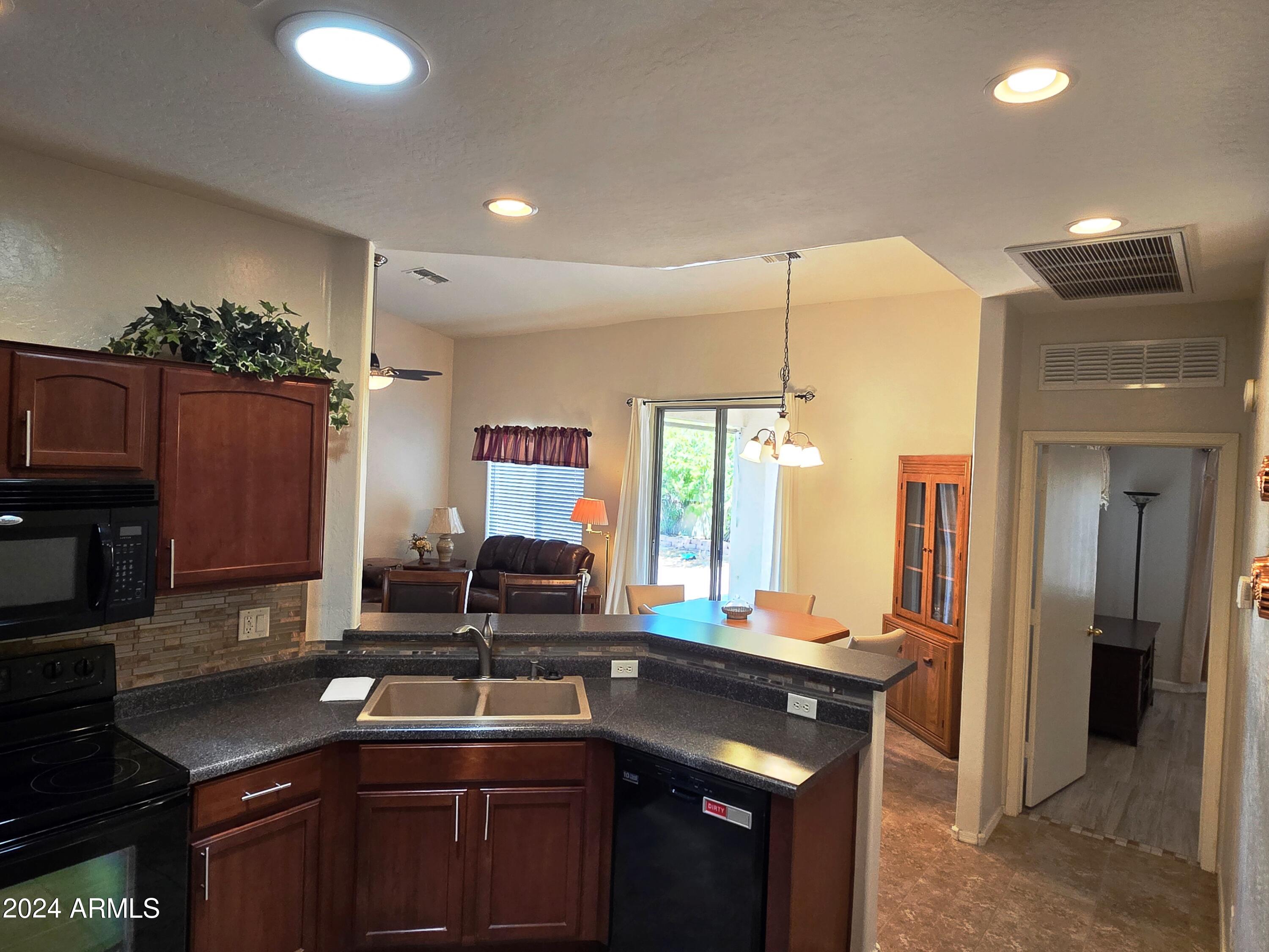 2101 South Meridian Road, Unit 34 Apache Junction, AZ 85120 - Photo 9 of 59 a kitchen with stainless steel appliances granite countertop a sink a stove and a refrigerator