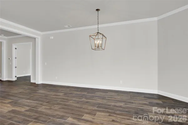 a view of a room with wooden floor and white walls