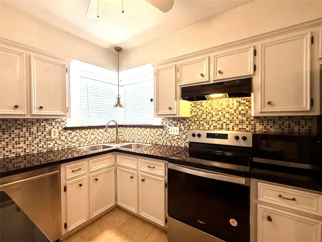 a kitchen with granite countertop white cabinets and white appliances