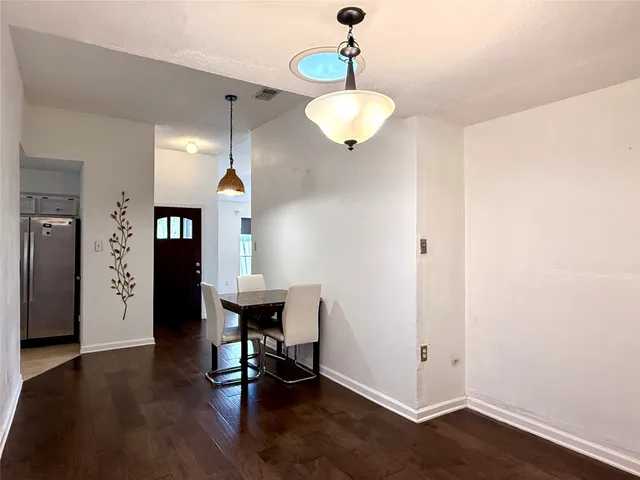 a view of a room with wooden floor and chairs