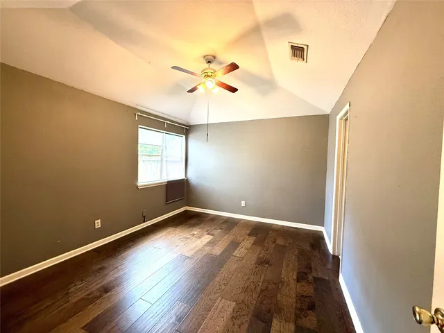 a view of a big room with wooden floor and windows