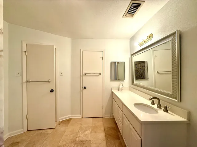 a bathroom with a double vanity sink a mirror and a bathtub