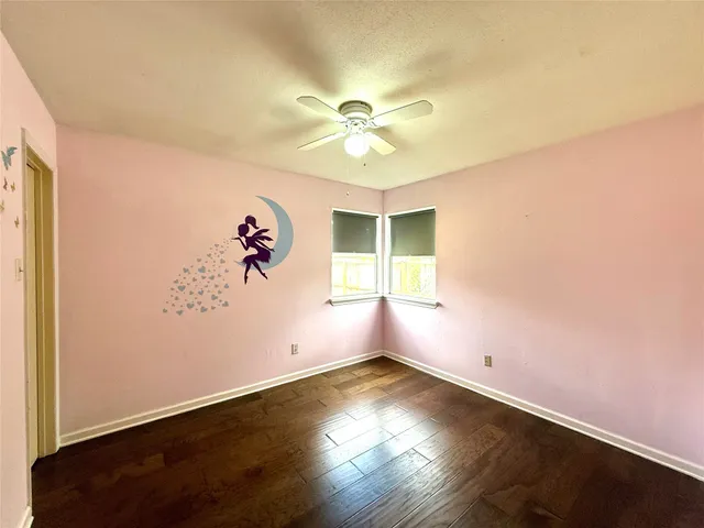 an empty room with a window and wooden floor