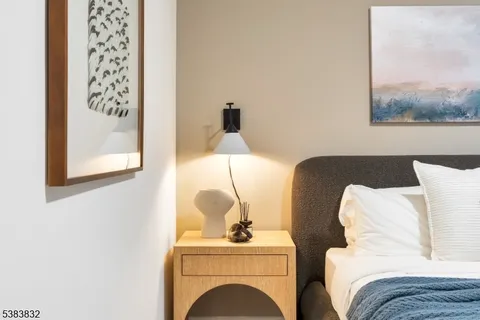 a bedroom with a bed and a painting on the wall