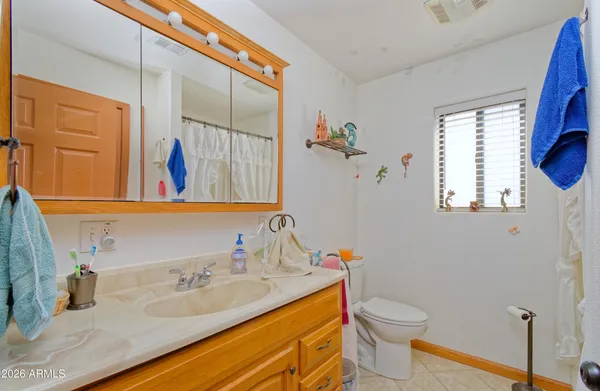 a bathroom with a granite countertop sink mirror vanity and toilet