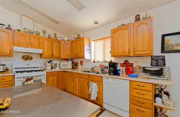 a kitchen with stainless steel appliances a stove top oven a sink dishwasher and cabinets with wooden floor