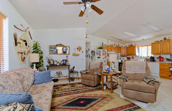 a living room with furniture kitchen view and a chandelier