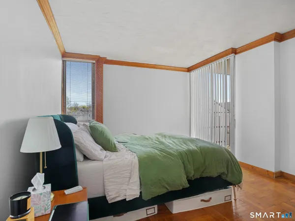 a bedroom with a bed and a lamp on dresser