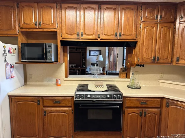 a kitchen with granite countertop a stove top oven cabinetry a sink and dishwasher