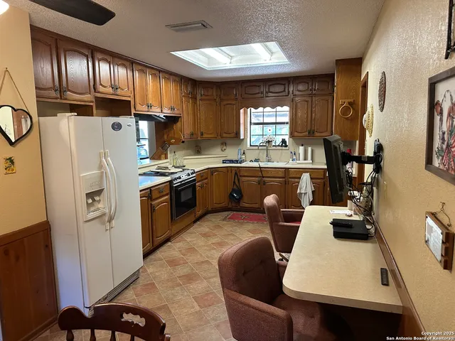 a kitchen with kitchen island granite countertop a sink appliances and cabinets
