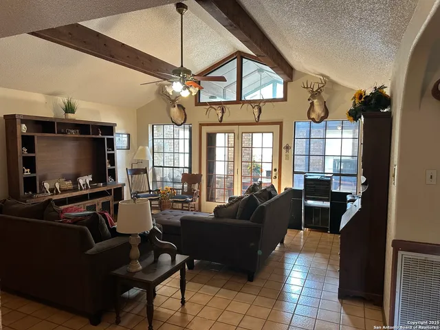 a living room with furniture a flat screen tv and a window