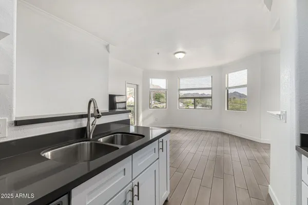 a kitchen with a sink and wooden floor