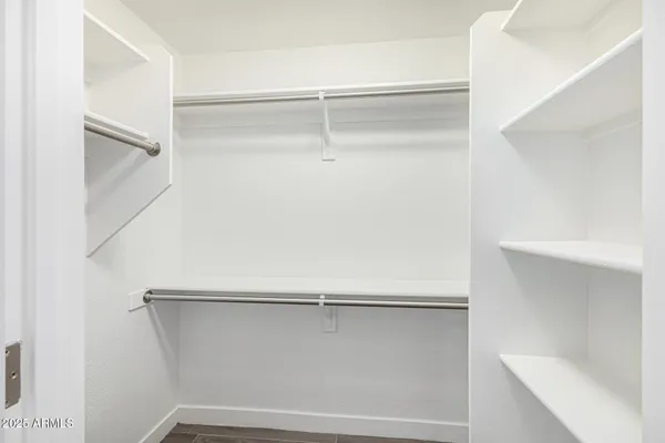 a view of walk in closet with empty racks