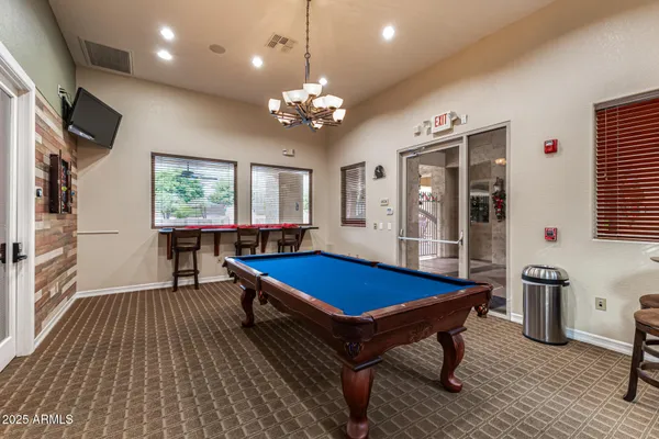 a room with pool table and windows
