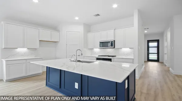 a kitchen with a sink a stove a refrigerator and white cabinets