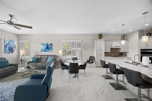 a living room with furniture a large window and kitchen view