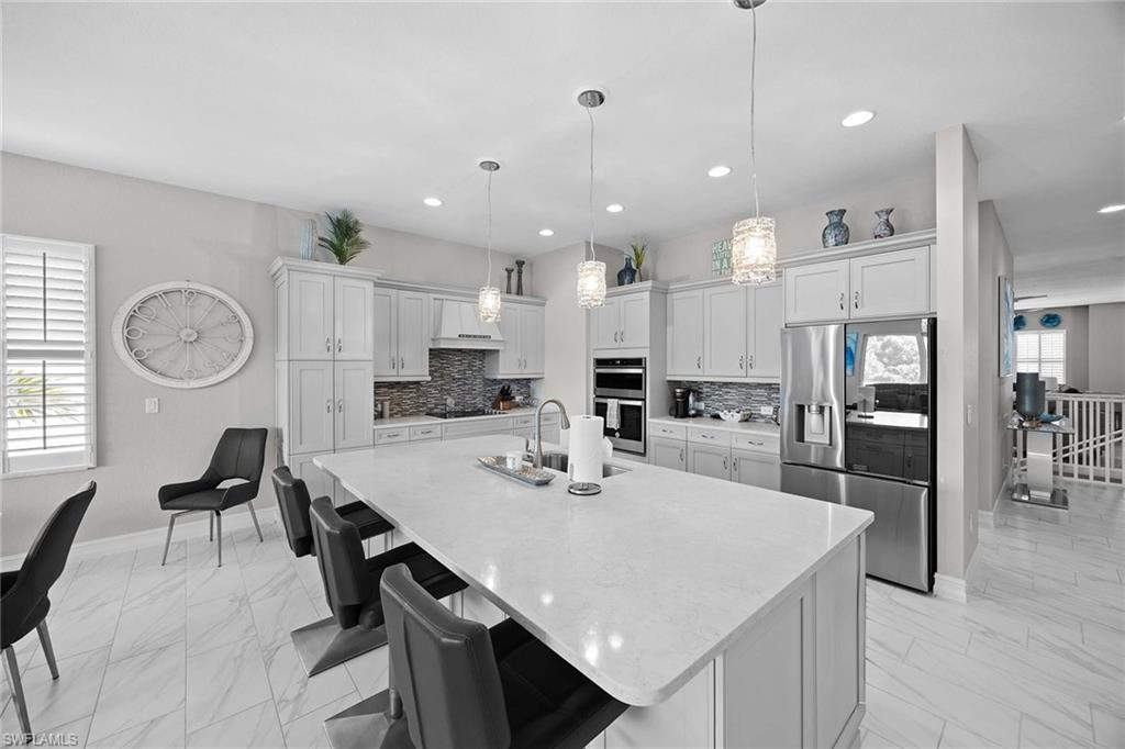 7781 Hawthorne Drive, Unit 3204 Naples, FL 34113 - Photo 17 of 50 a kitchen with a dining table chairs cabinets and stainless steel appliances