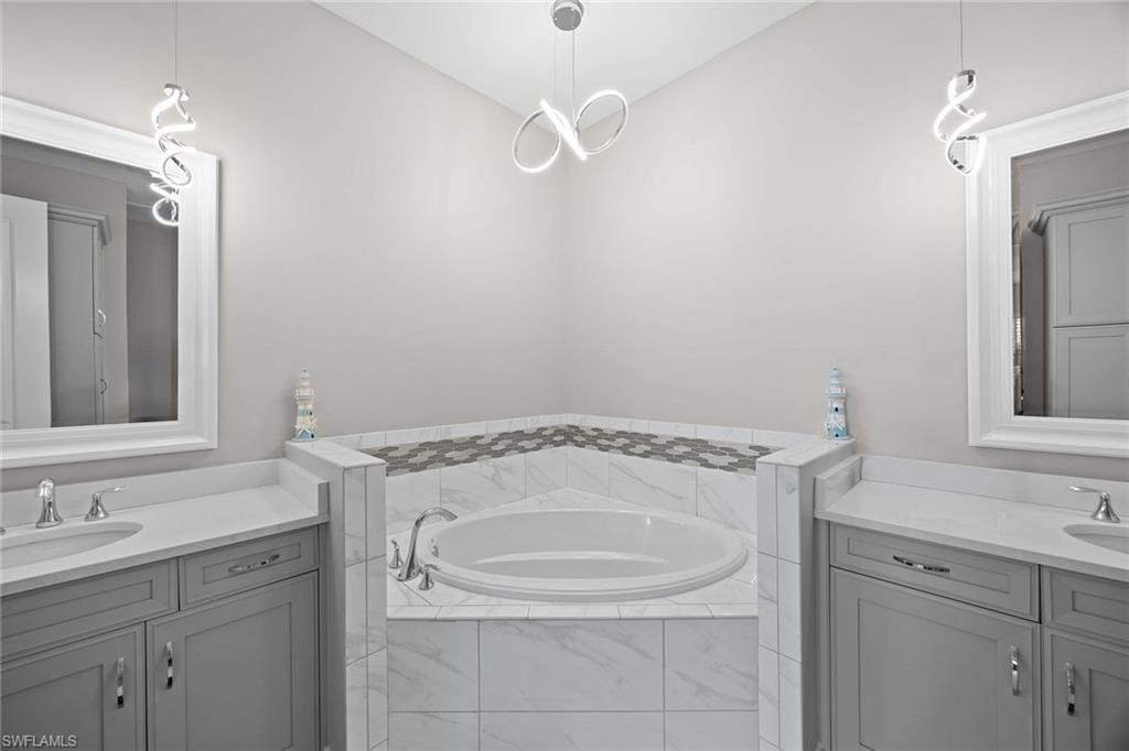 7781 Hawthorne Drive, Unit 3204 Naples, FL 34113 - Photo 24 of 50 a bathroom with a granite countertop sink and a mirror