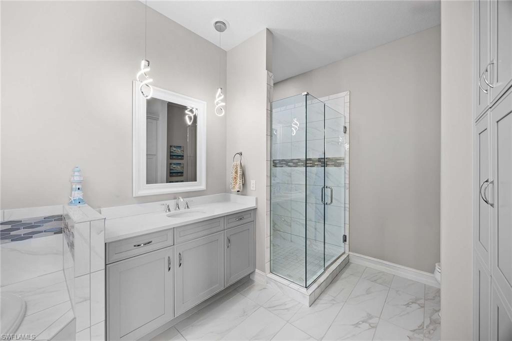 7781 Hawthorne Drive, Unit 3204 Naples, FL 34113 - Photo 26 of 50 a bathroom with a shower sink and mirror