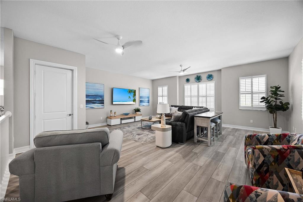 7781 Hawthorne Drive, Unit 3204 Naples, FL 34113 - Photo 33 of 50 a living room with furniture a dining table and wooden floor