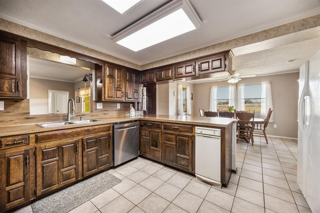 1439 Davis Lane Terrell, TX 75160 - Photo 12 of 33 a large kitchen with cabinets and chairs