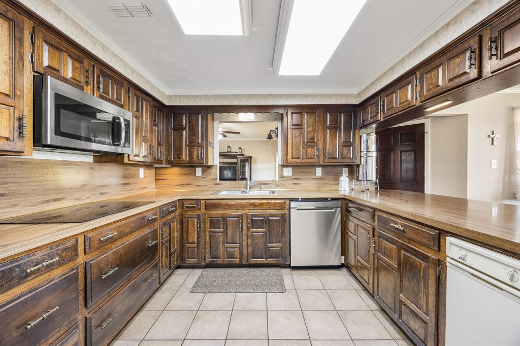 1439 Davis Lane Terrell, TX 75160 - Photo 13 of 33 a large kitchen with stainless steel appliances granite countertop a sink and cabinets