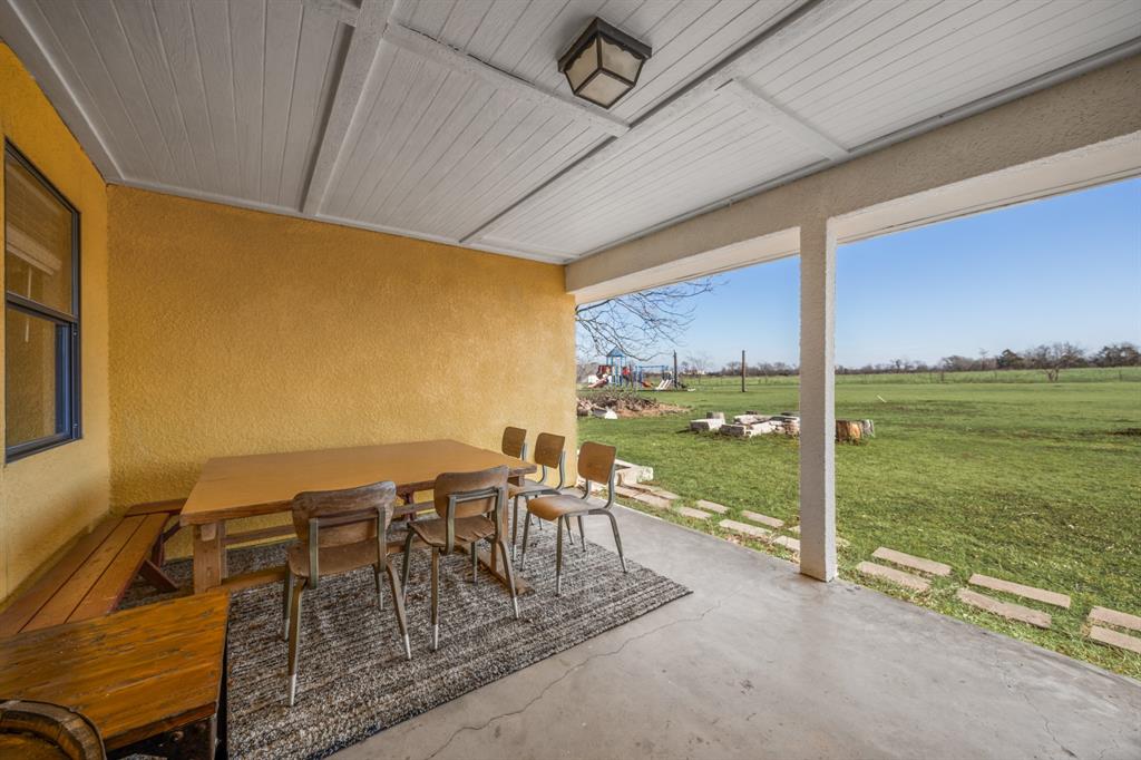 1439 Davis Lane Terrell, TX 75160 - Photo 28 of 33 a view of a patio with lawn chairs floor to ceiling window and an outdoor view