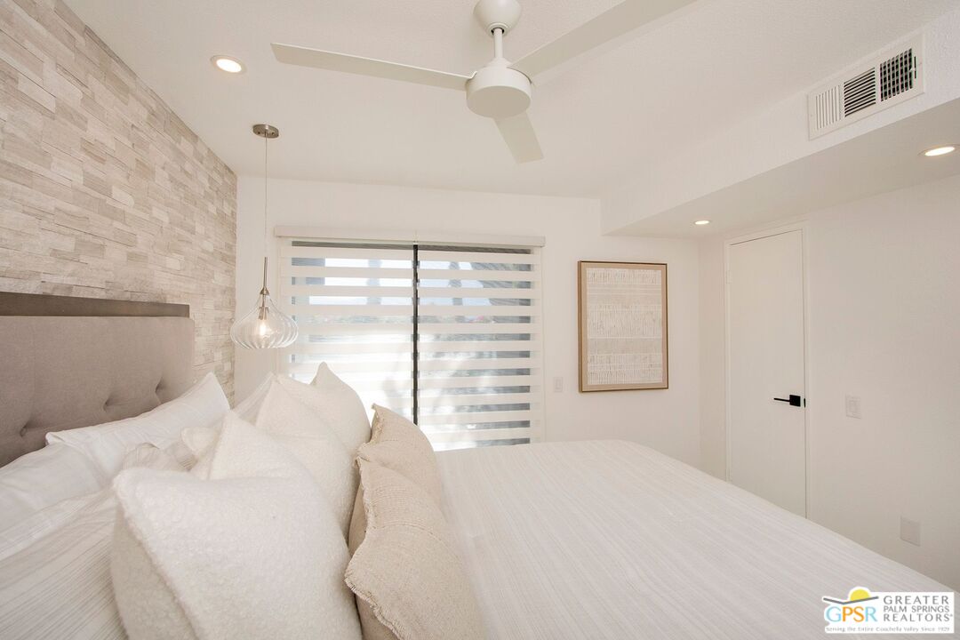 1100 East Amado Road, Unit 13C1 Palm Springs, CA 92262 - Photo 13 of 36 a bedroom with a large bed and a large window