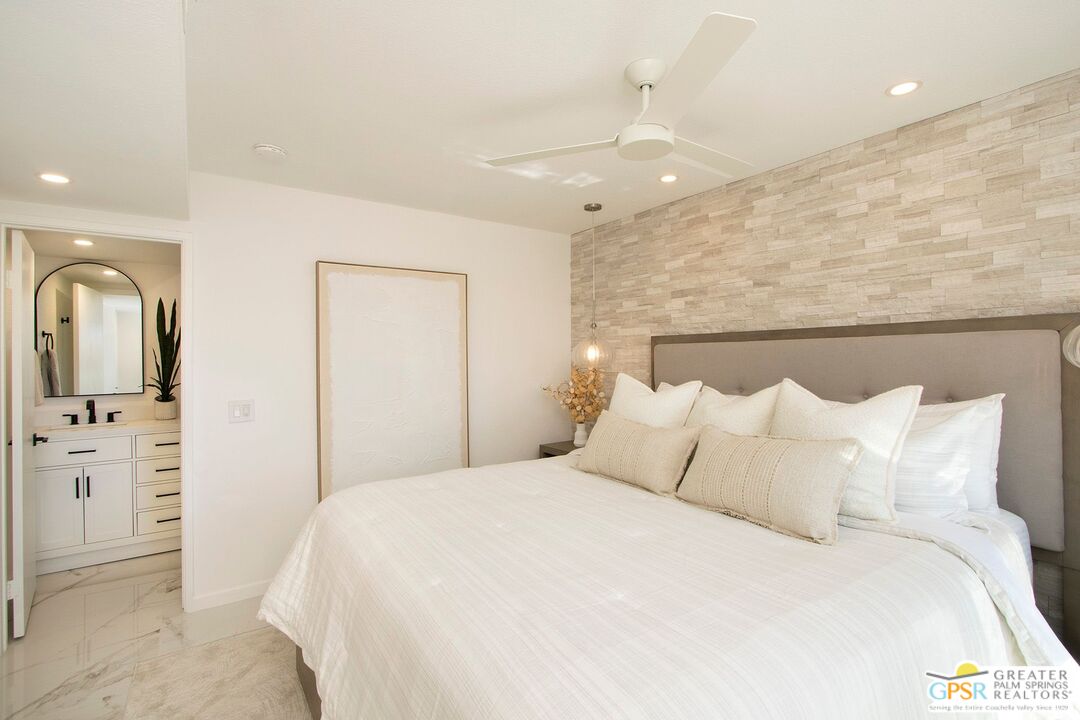 1100 East Amado Road, Unit 13C1 Palm Springs, CA 92262 - Photo 14 of 36 a bedroom with a large bed and chandelier