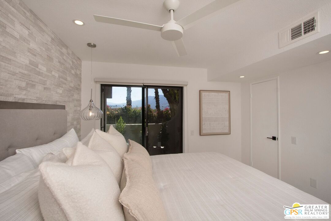 1100 East Amado Road, Unit 13C1 Palm Springs, CA 92262 - Photo 19 of 36 a bedroom with a bed and a large window