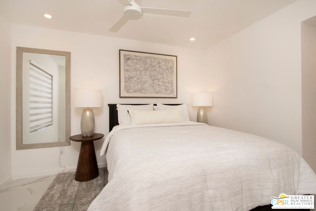 1100 East Amado Road, Unit 13C1 Palm Springs, CA 92262 - Photo 22 of 36 a bedroom with a bed and wooden floor
