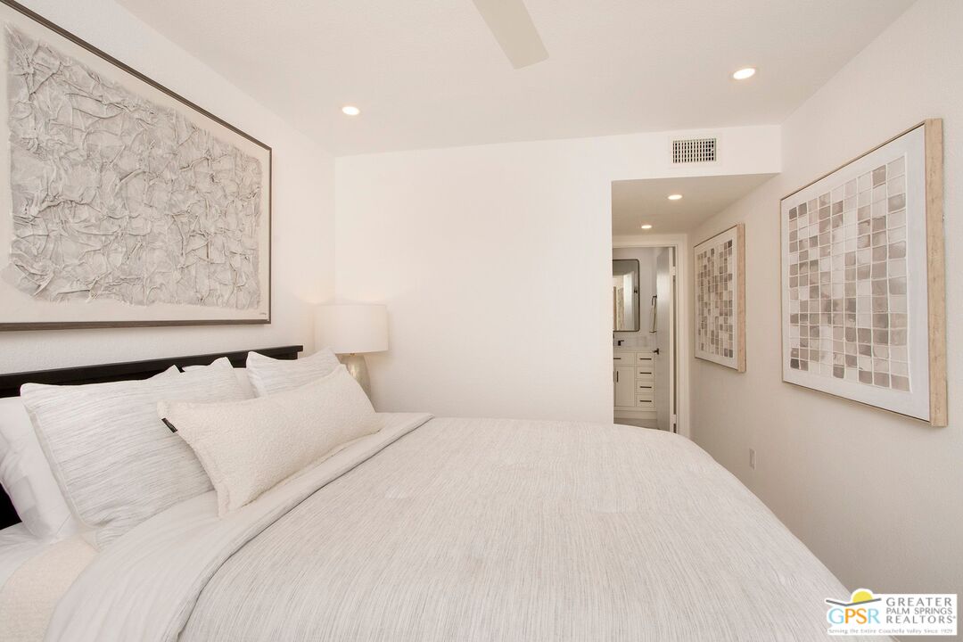 1100 East Amado Road, Unit 13C1 Palm Springs, CA 92262 - Photo 24 of 36 a large white bed in a white room