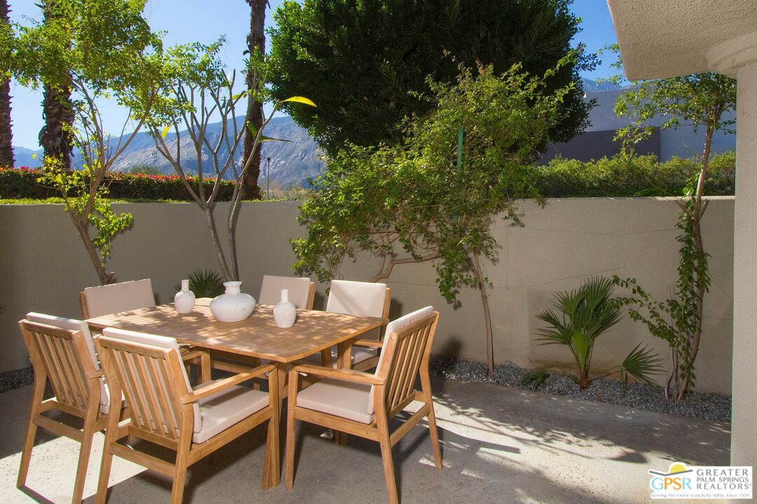 1100 East Amado Road, Unit 13C1 Palm Springs, CA 92262 - Photo 28 of 36 a view of a patio with table and chairs and potted plants