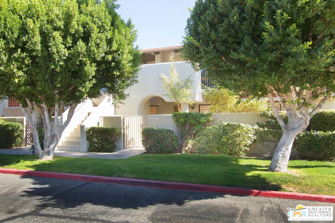 1100 East Amado Road, Unit 13C1 Palm Springs, CA 92262 - Photo 31 of 36 a view of a white house with a yard