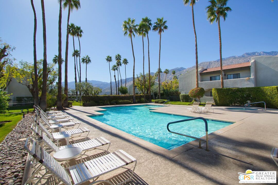 1100 East Amado Road, Unit 13C1 Palm Springs, CA 92262 - Photo 33 of 36 a view of swimming pool with a table and chairs