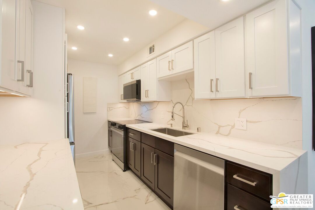 1100 East Amado Road, Unit 13C1 Palm Springs, CA 92262 - Photo 8 of 36 a kitchen with stainless steel appliances granite countertop a sink stove and cabinets