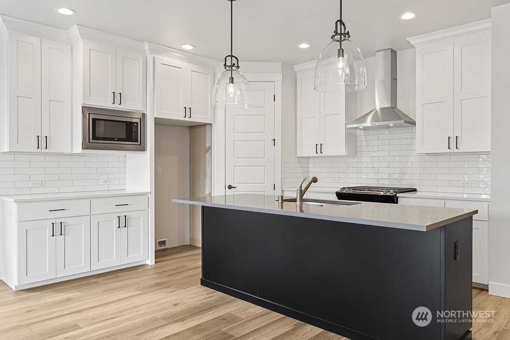 1036 Okerlund Drive Enumclaw, WA 98022 - Photo 8 of 23 a kitchen with stainless steel appliances granite countertop a sink a stove a refrigerator and island with wooden floor