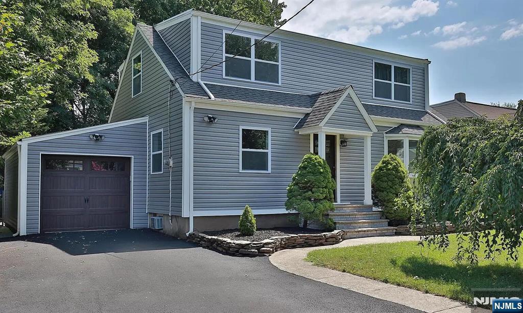 7-09 Dewey Place, Unit 1 Fair Lawn, NJ 07410 - Photo 2 of 7 a front view of a house with a yard and garage
