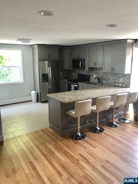 7-09 Dewey Place, Unit 1 Fair Lawn, NJ 07410 - Photo 3 of 7 a view of a kitchen with kitchen island a counter top space a sink stainless steel appliances and cabinets