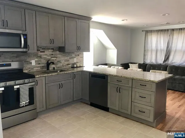 a kitchen with cabinets appliances a sink and a window