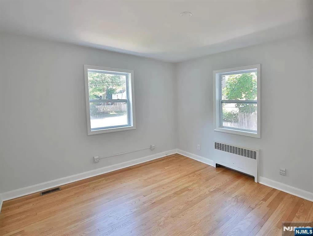 7-09 Dewey Place, Unit 1 Fair Lawn, NJ 07410 - Photo 6 of 7 an empty room with wooden floor and windows