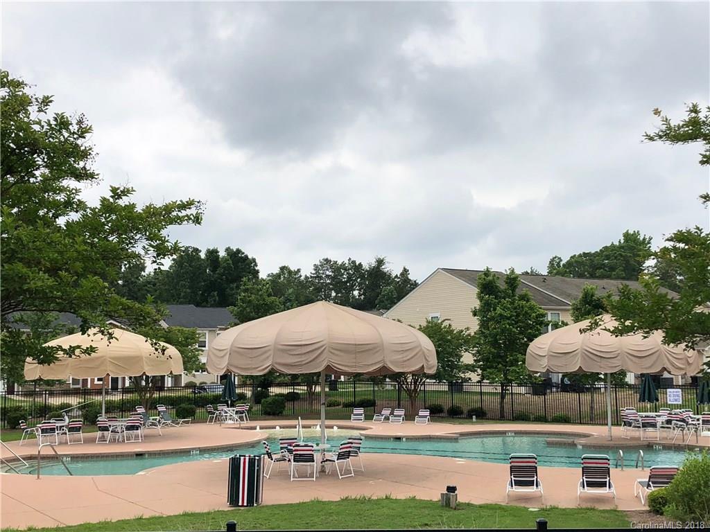 667 Potter Place Road, Unit 104 Fort Mill, SC 29708 - Photo 22 of 22 a view of a big yard with lawn chairs under an umbrella