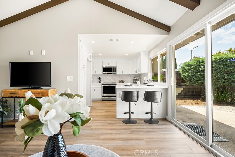 14331 Fernbrook Drive Tustin, CA 92780 - Photo 14 of 35 a living room with furniture a flat screen tv and a floor to ceiling window
