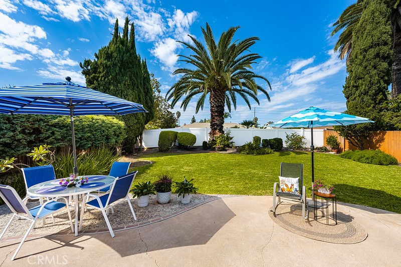 14331 Fernbrook Drive Tustin, CA 92780 - Photo 30 of 35 a view of a backyard with table and chairs under an umbrella with palm trees