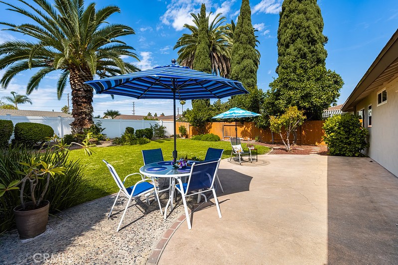 14331 Fernbrook Drive Tustin, CA 92780 - Photo 31 of 35 a view of patio with chairs and table under an umbrella with palm trees