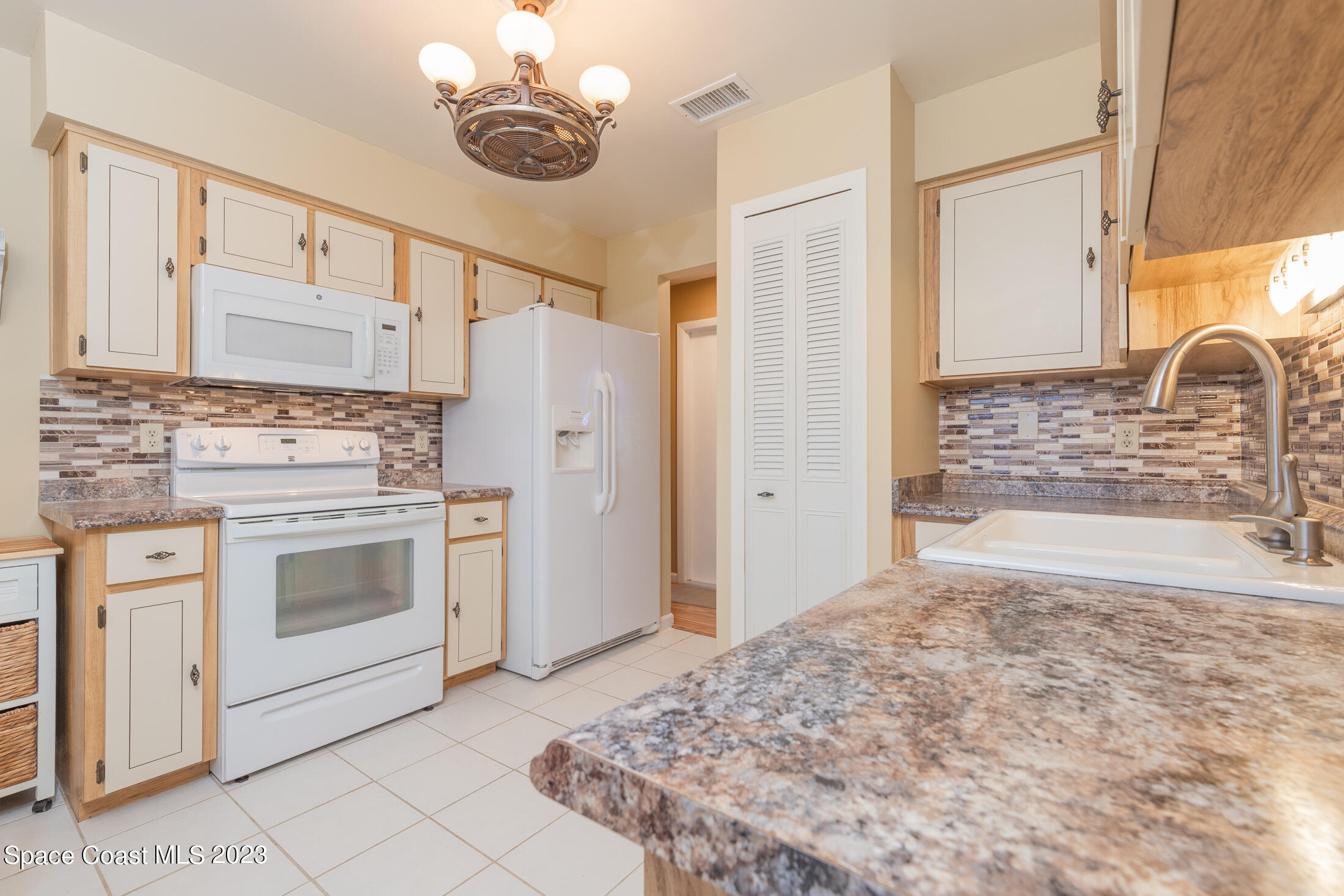 978 Locust Avenue Palm Bay, FL 32907 - Photo 21 of 41 a kitchen with stainless steel appliances a stove microwave and a refrigerator