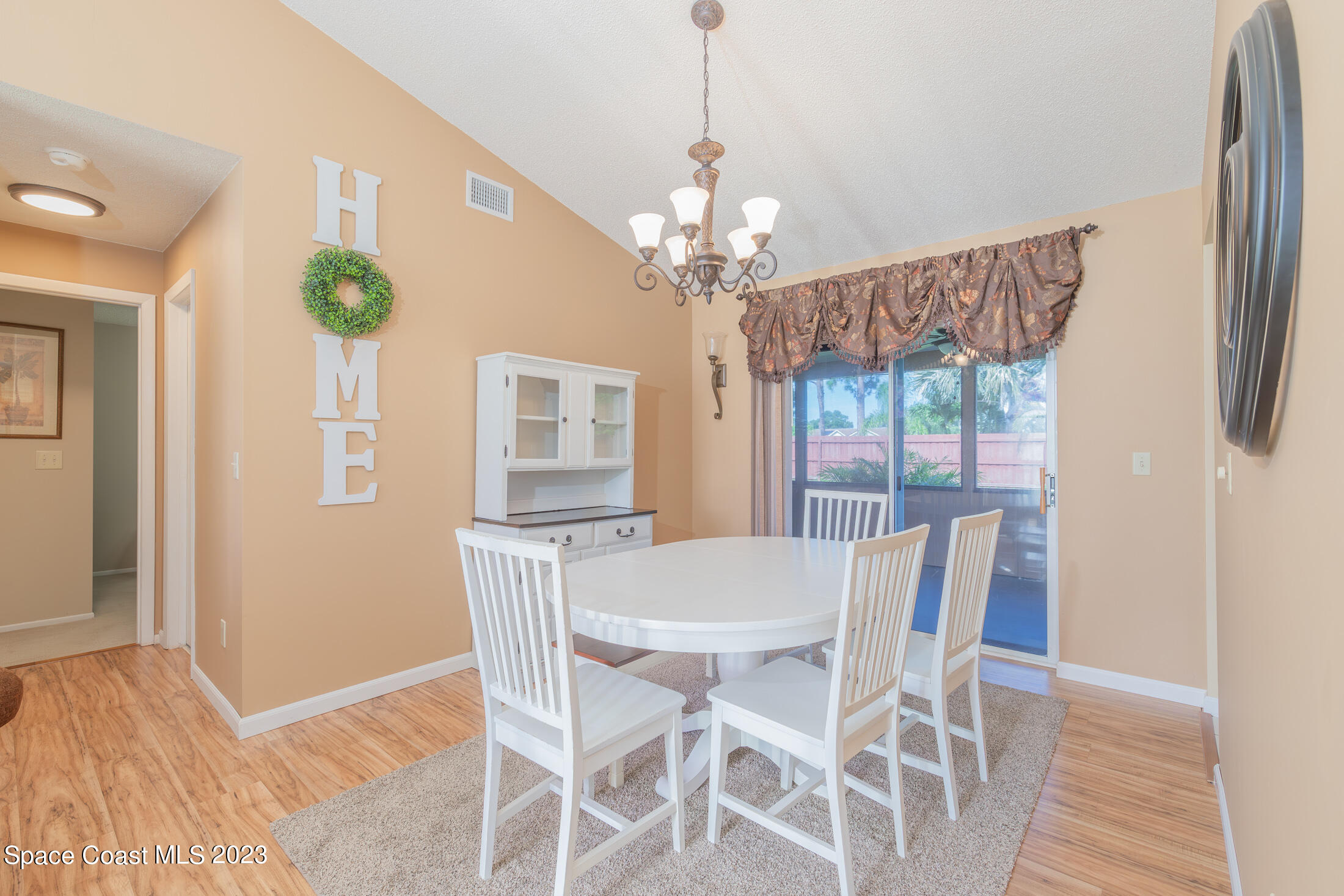 978 Locust Avenue Palm Bay, FL 32907 - Photo 5 of 41 a view of a dining room with furniture a chandelier and wooden floor