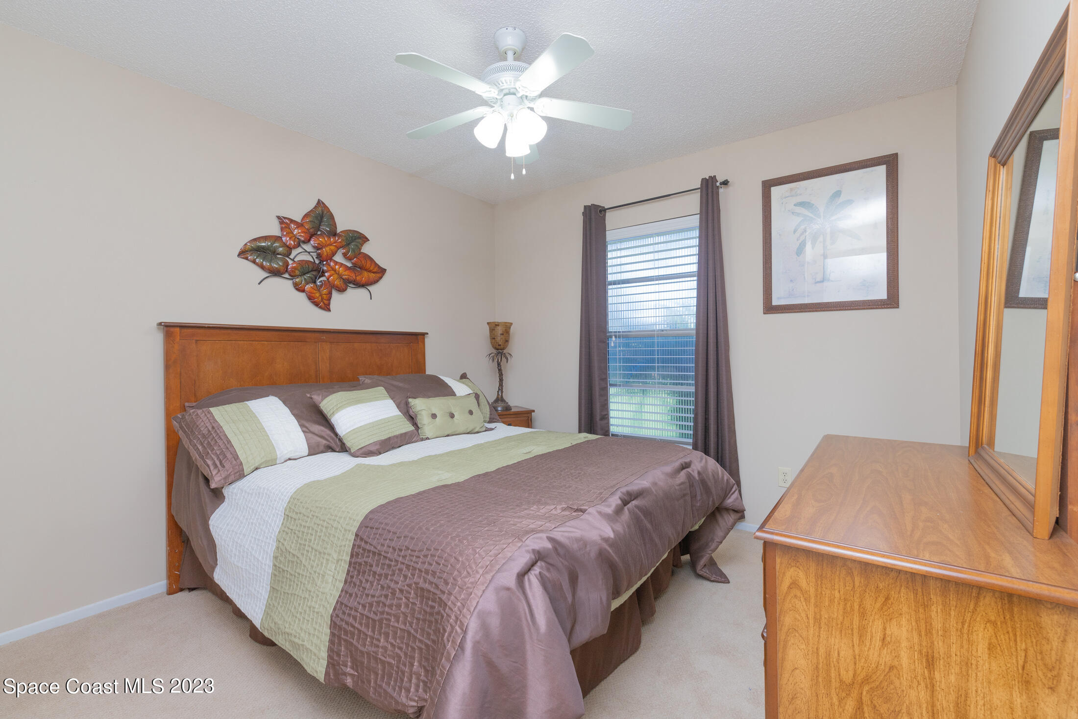 978 Locust Avenue Palm Bay, FL 32907 - Photo 8 of 41 a bedroom with a large bed and a chandelier